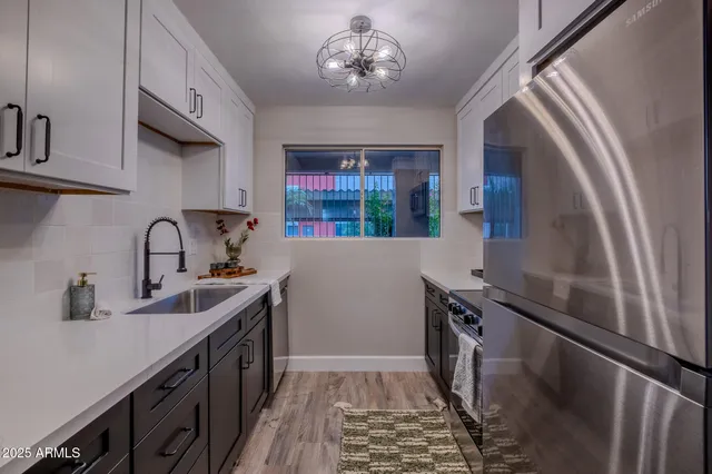 a kitchen with stainless steel appliances a sink stove and cabinets