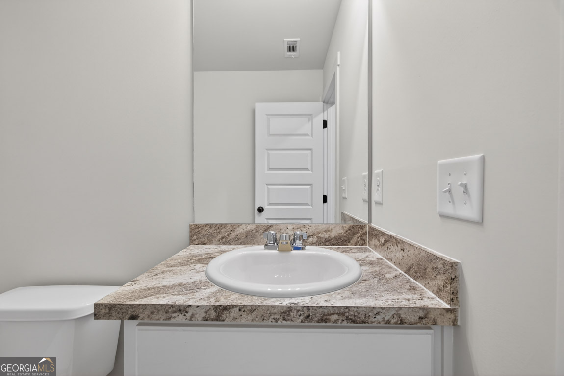 110 Chad Walk, Unit 56 Statham, GA 30666 - Photo 36 of 53 a bathroom with a granite countertop sink and a mirror