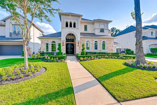 a front view of a house with a yard and potted plants