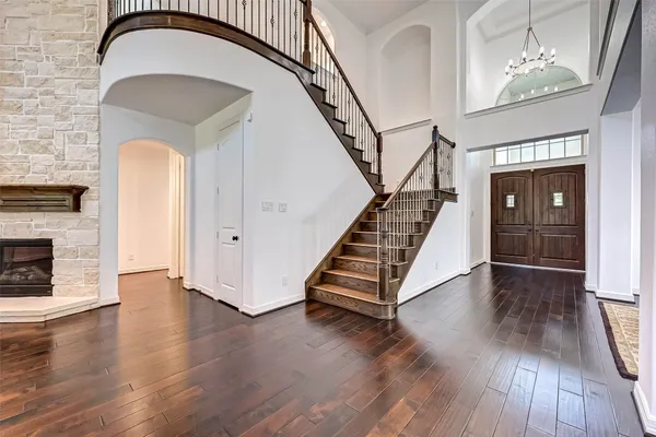 a view of a livingroom with wooden floor staircase and a fireplace