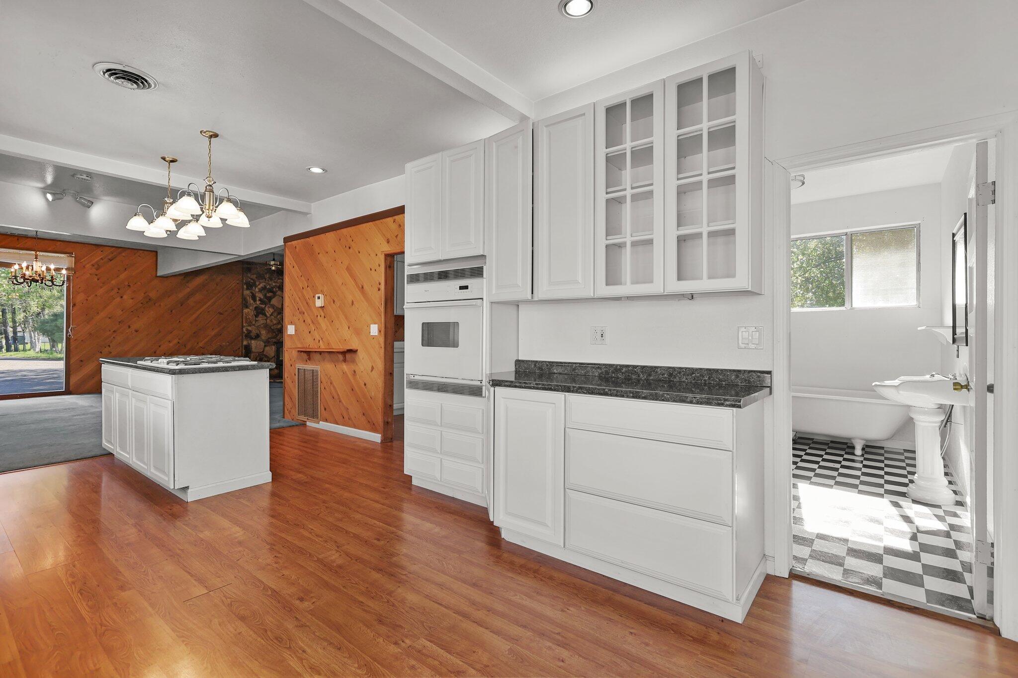 16588 Stanislaus Drive Redding, CA 96001 - Photo 14 of 53 a kitchen with stainless steel appliances granite countertop a stove top oven a sink dishwasher and a refrigerator with wooden floor