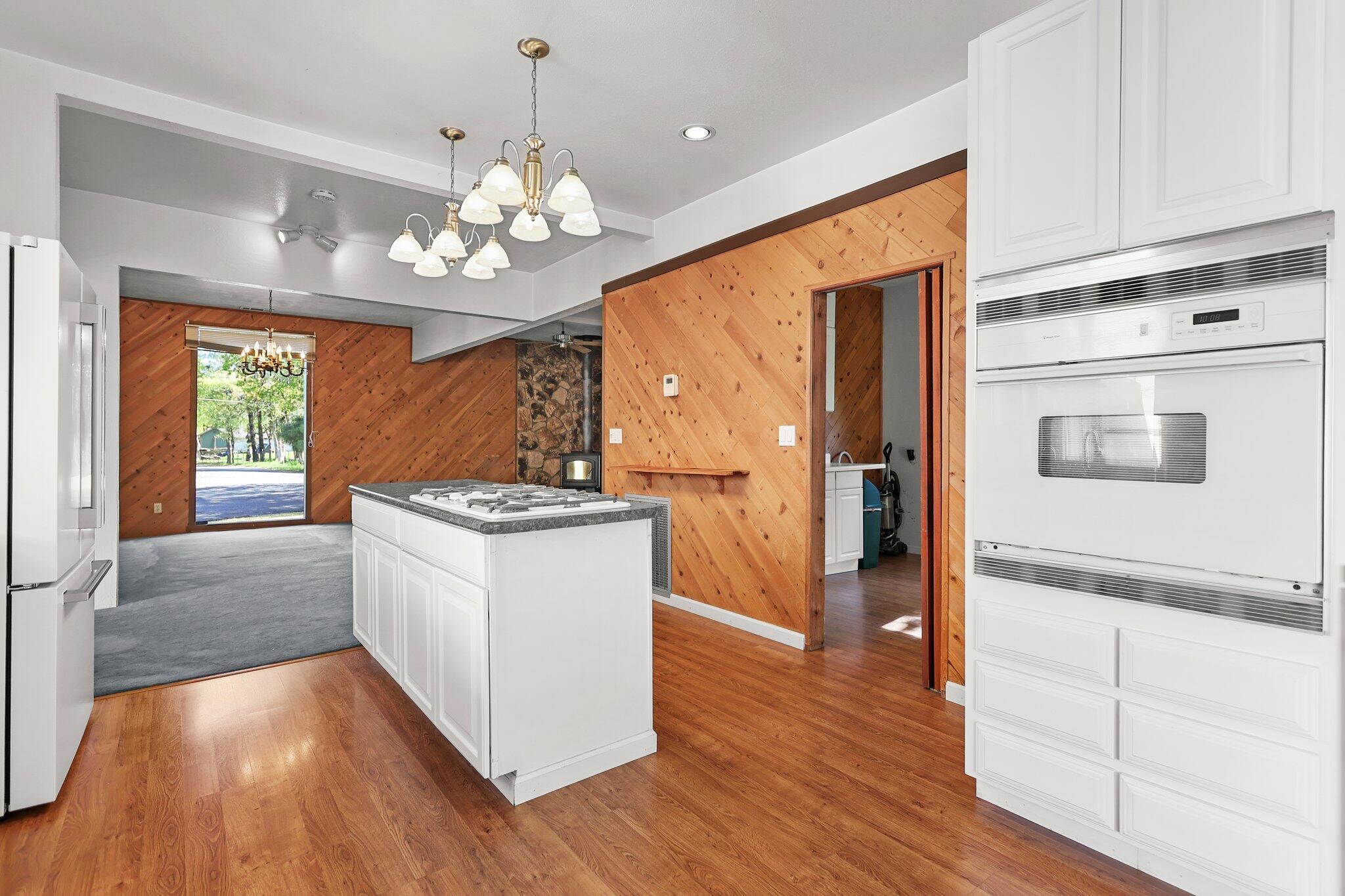 16588 Stanislaus Drive Redding, CA 96001 - Photo 16 of 53 a kitchen with stainless steel appliances granite countertop wooden floors and white cabinets