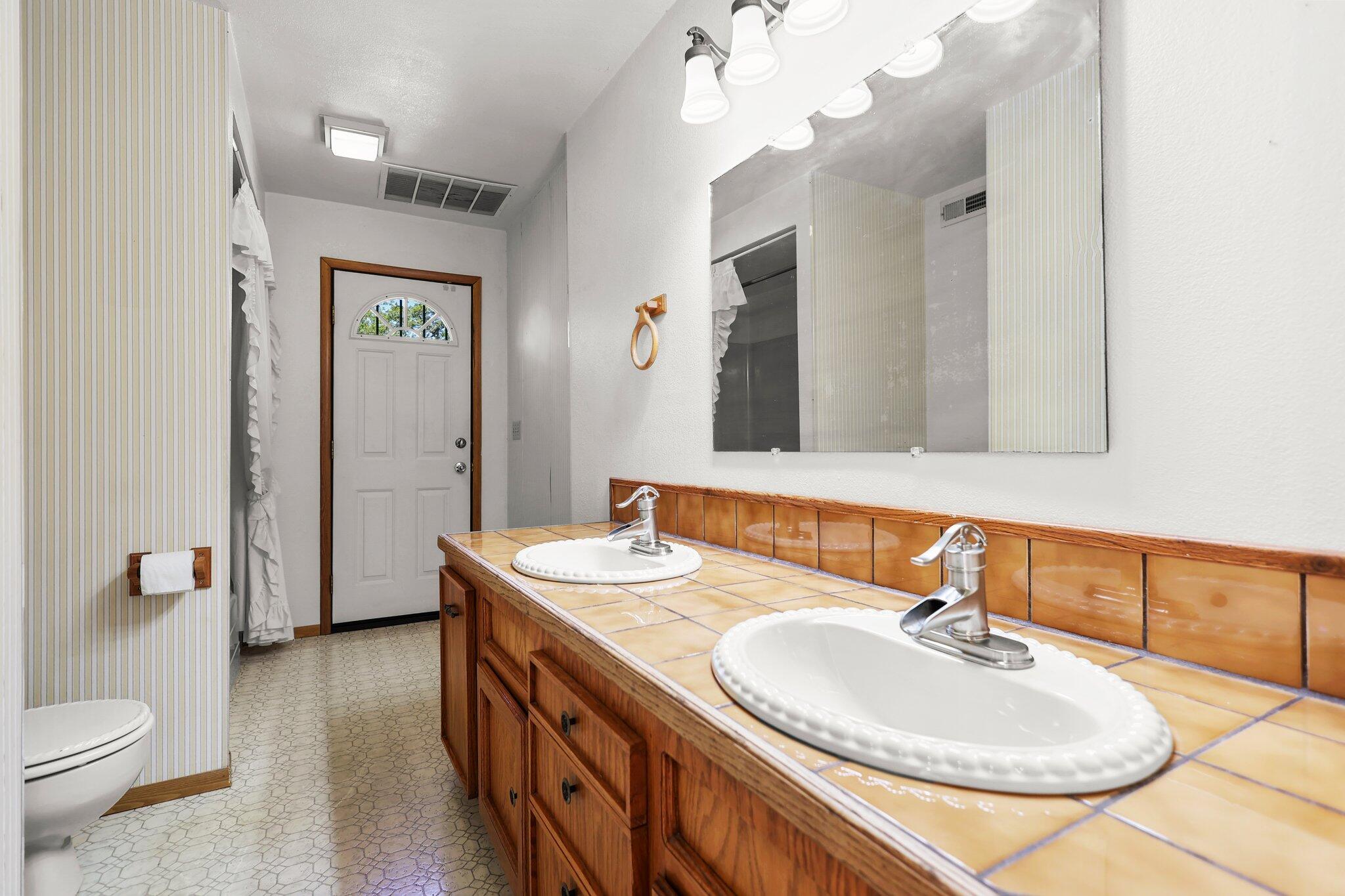 16588 Stanislaus Drive Redding, CA 96001 - Photo 23 of 53 a bathroom with a double vanity sink mirror and toilet