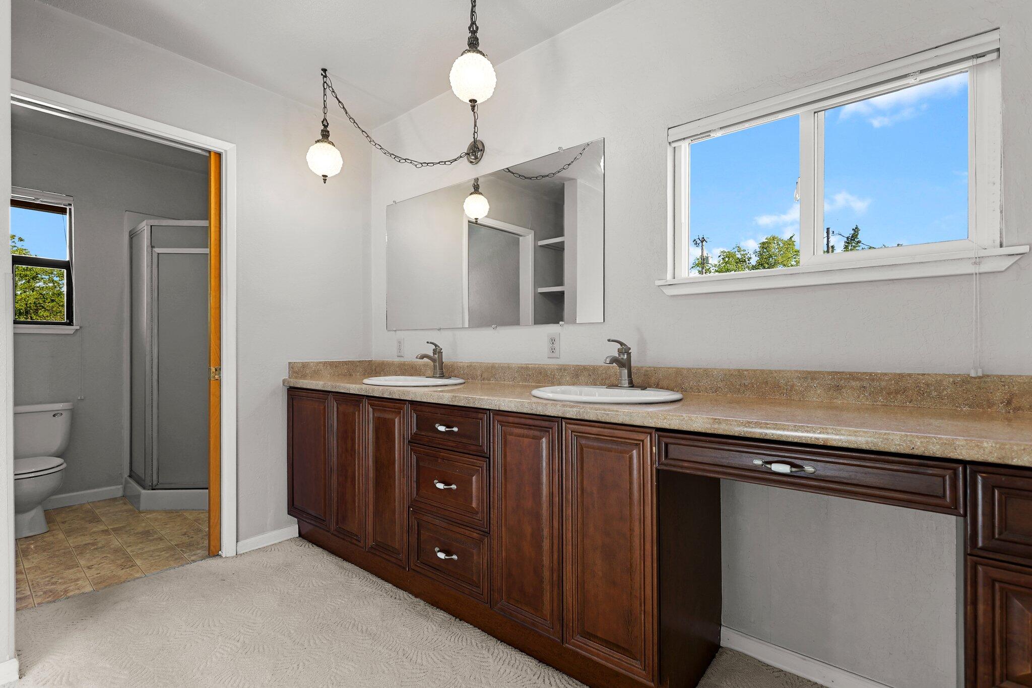 16588 Stanislaus Drive Redding, CA 96001 - Photo 37 of 53 a bathroom with a granite countertop sink a large mirror and a window