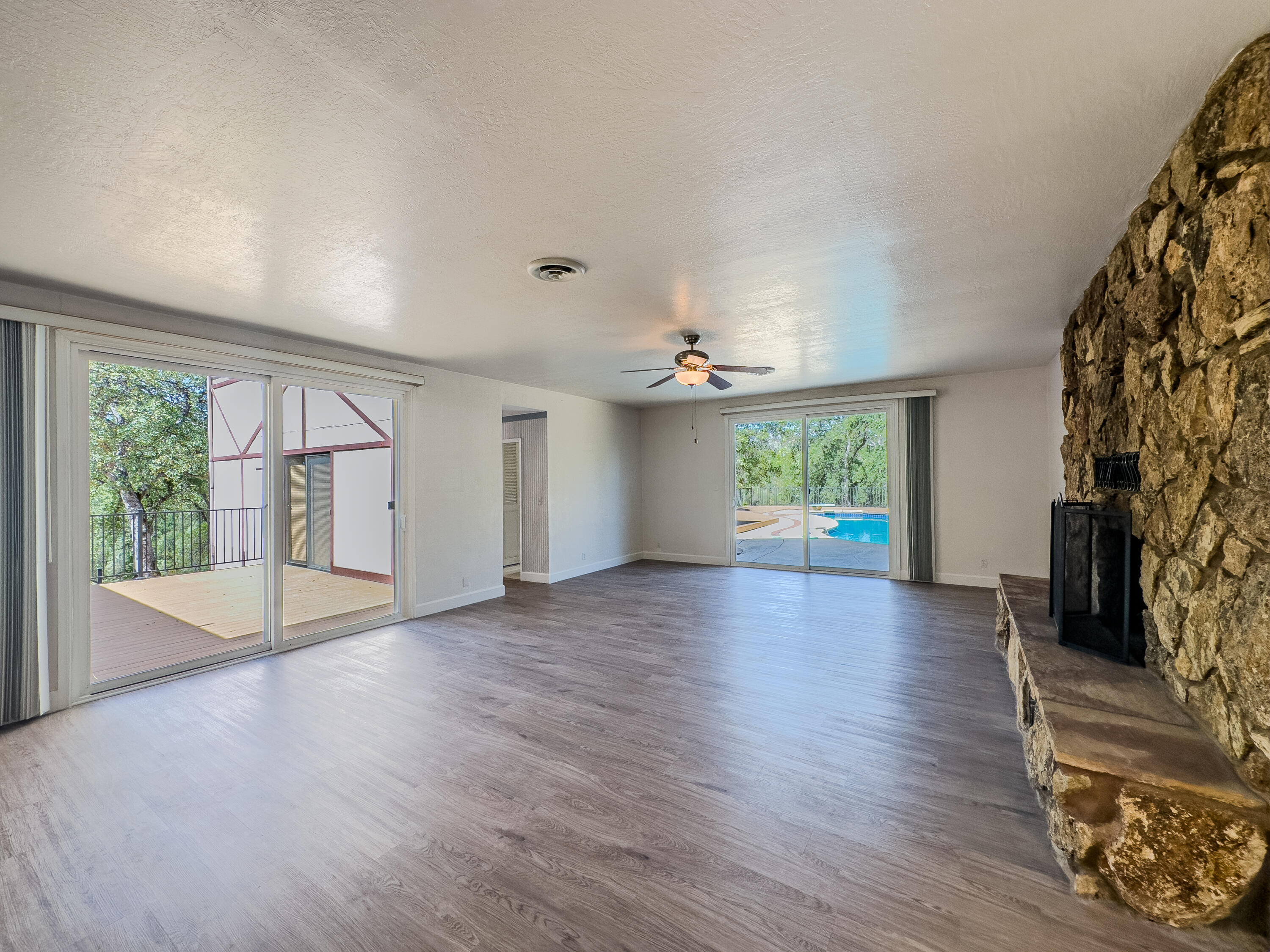 16588 Stanislaus Drive Redding, CA 96001 - Photo 8 of 53 an empty room with wooden floor and windows