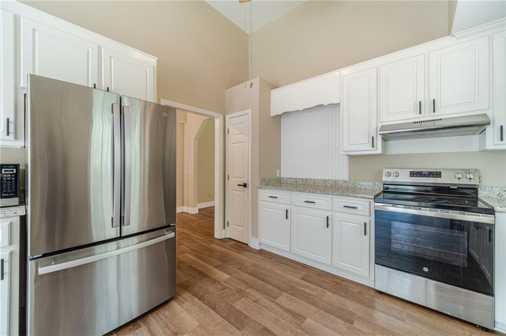 246 Azalea Farms Road Social Circle, GA 30025 - Photo 11 of 27 a kitchen with stainless steel appliances granite countertop a refrigerator stove and white cabinets