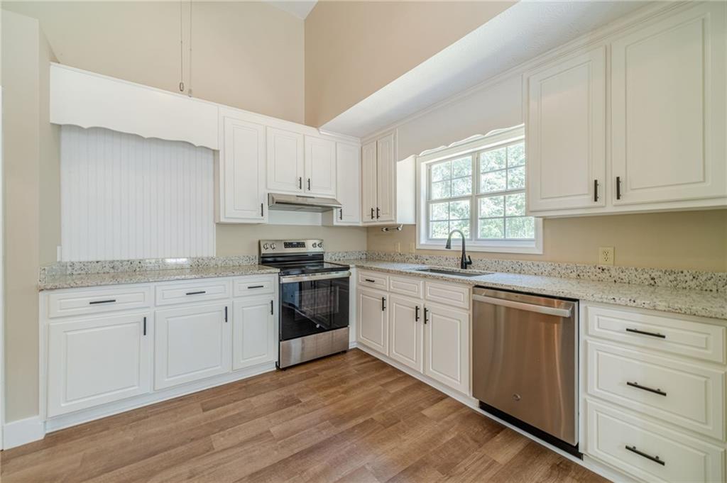 246 Azalea Farms Road Social Circle, GA 30025 - Photo 12 of 27 a kitchen with granite countertop cabinets stainless steel appliances a sink and a window