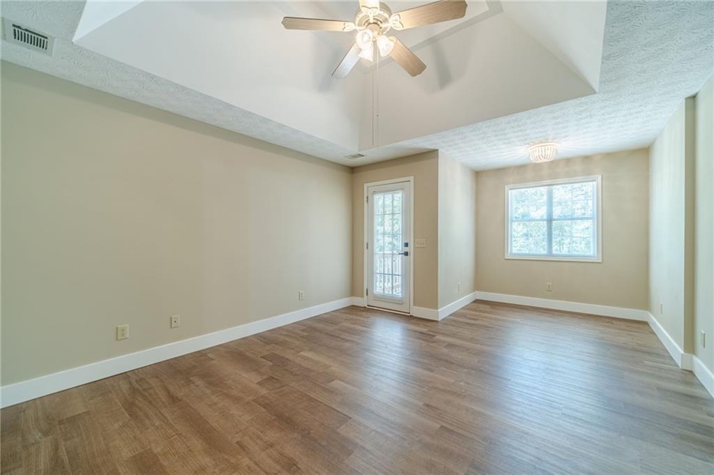246 Azalea Farms Road Social Circle, GA 30025 - Photo 14 of 27 an empty room with wooden floor chandelier fan and windows
