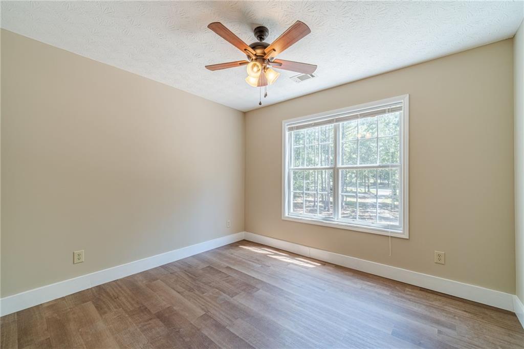 246 Azalea Farms Road Social Circle, GA 30025 - Photo 20 of 27 an empty room with wooden floor and ceiling fan