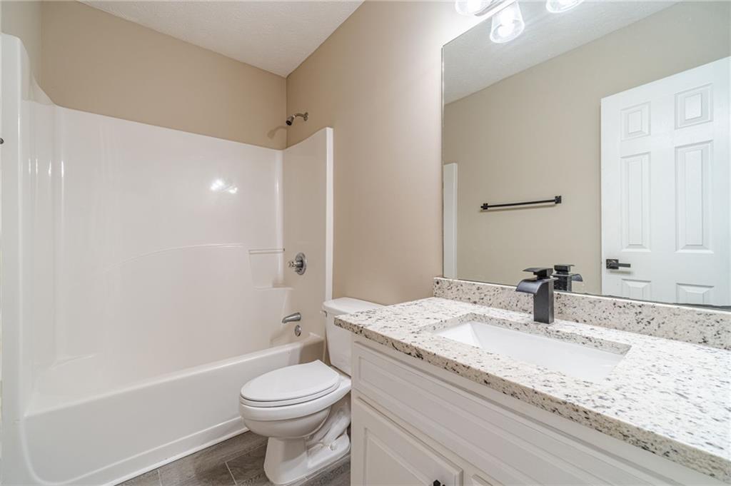 246 Azalea Farms Road Social Circle, GA 30025 - Photo 25 of 27 a bathroom with a granite countertop sink toilet and shower