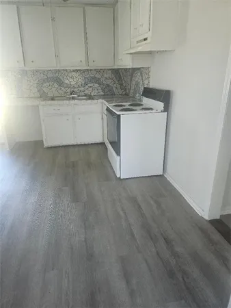 a kitchen with granite countertop white cabinets and white appliances