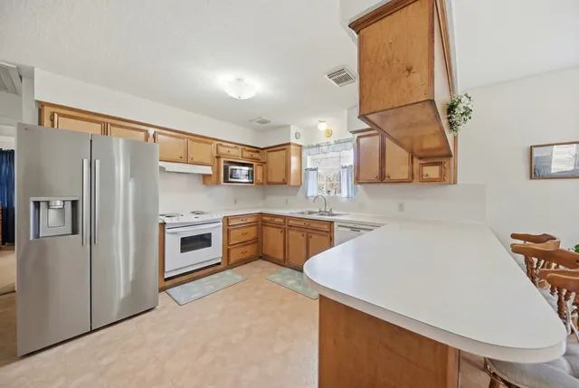 a kitchen with stainless steel appliances a refrigerator sink and stove