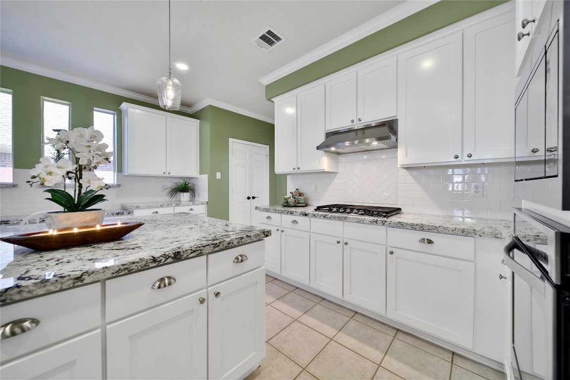 3622 Chessnut Glen Drive Spring, TX 77388 - Photo 13 of 38 a kitchen with stainless steel appliances granite countertop a sink a stove and white cabinets with wooden floor
