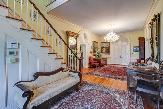 a view of a dining room with furniture a rug and wooden floor