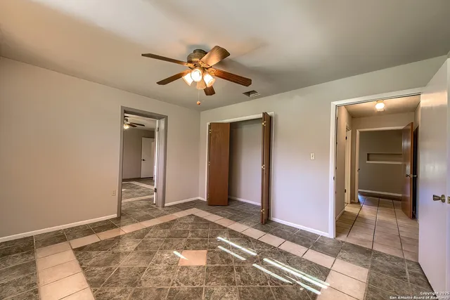 a view of a hallway with a chandelier fan and windows