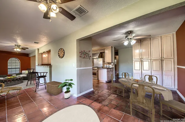 a living room with couches a dining table and chairs with wooden floor