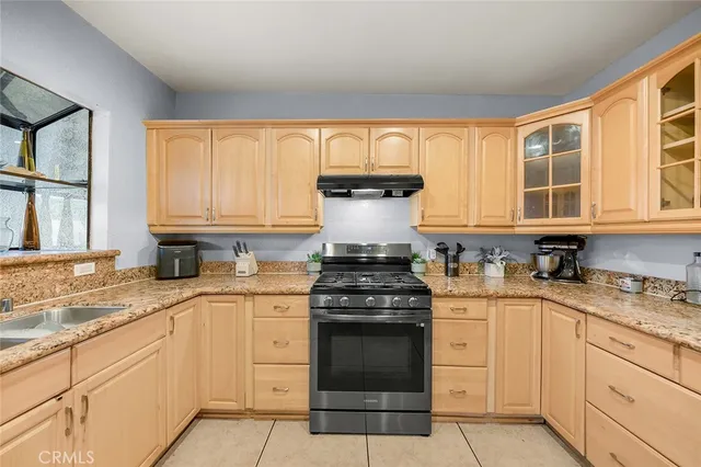 a kitchen with granite countertop a sink stainless steel appliances and cabinets