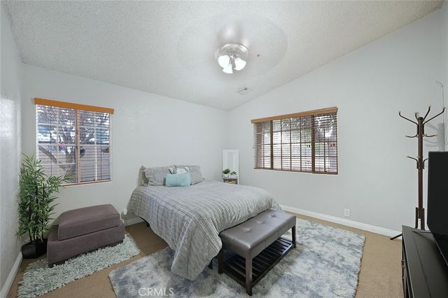 a bedroom with a large bed and a flat tv screen on a dresser