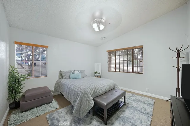 a bedroom with a large bed and a flat tv screen on a dresser