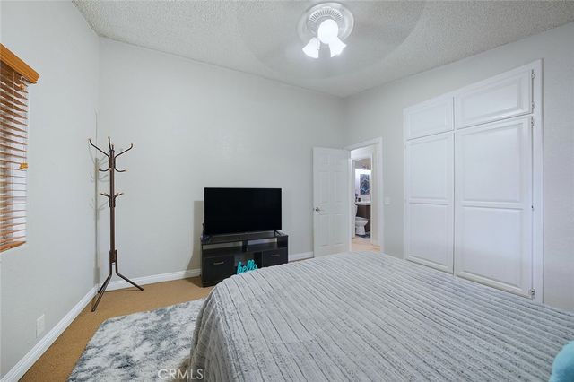 a bedroom with a bed and a ceiling fan