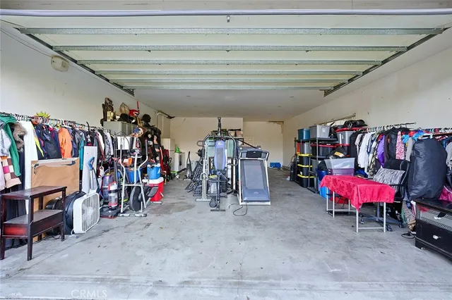 a living room with couches and kitchen view with wooden floor