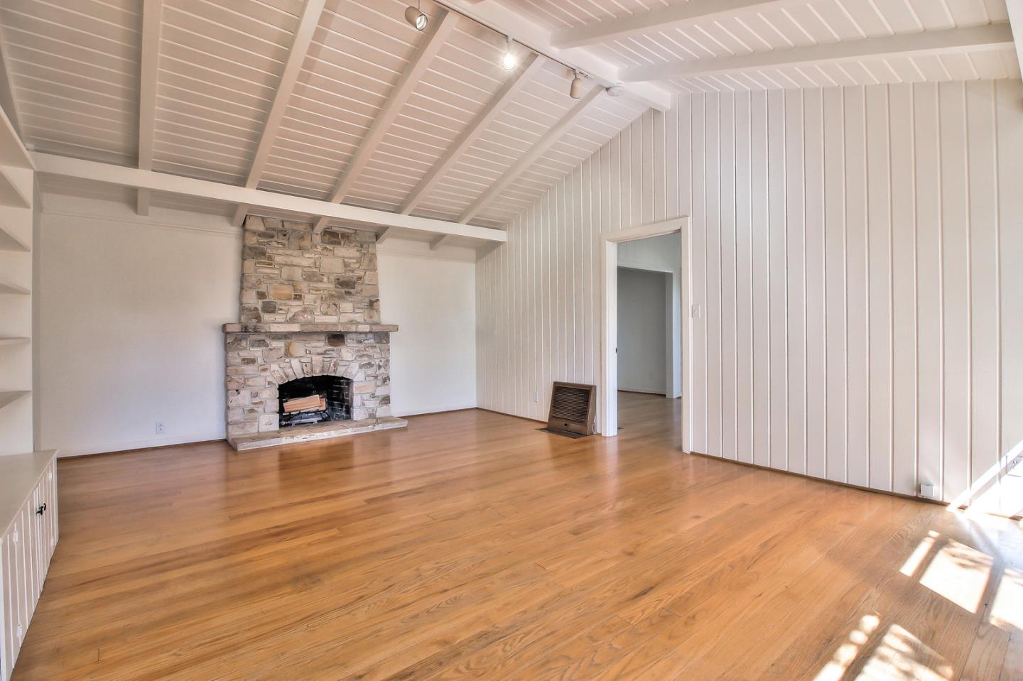 2 San Carlos Street Carmel, CA 93921 - Photo 5 of 22 a view of empty room with wooden floor and fireplace