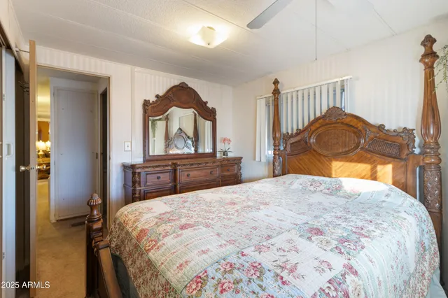 a bedroom with a bed and a dresser with mirror