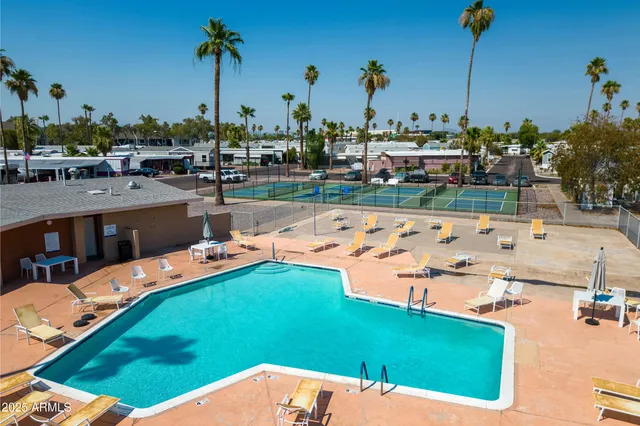 a view of a swimming pool with outdoor seating and buildings in the background