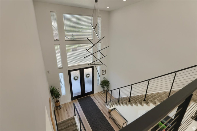828 South Deer Road Tooele, UT 84074 - Photo 23 of 51 Two-story foyer featuring a contemporary chandelier, abundant natural light from multiple windows, and a cable railing staircase