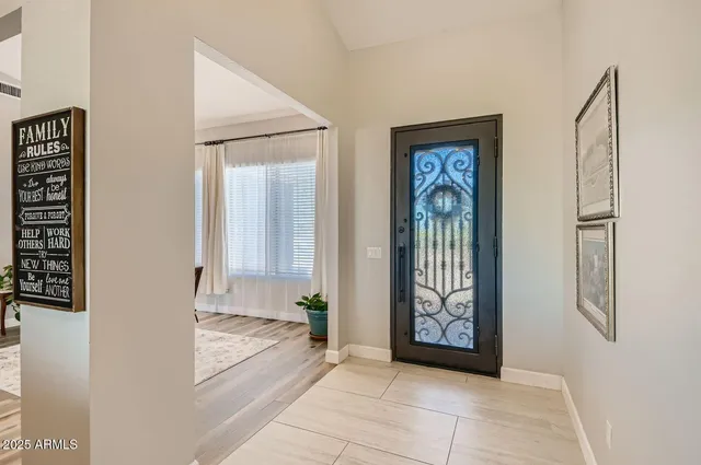 a living room with furniture kitchen view and a wooden floor