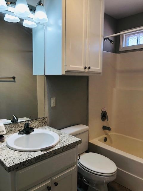 4412 Jarvis Street, Unit 2 Lubbock, TX 79416 - Photo 13 of 16 a bathroom with a granite countertop toilet sink and mirror