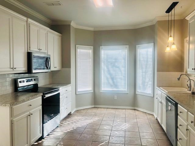 4412 Jarvis Street, Unit 2 Lubbock, TX 79416 - Photo 2 of 16 a kitchen with stainless steel appliances granite countertop a stove a sink and a microwave