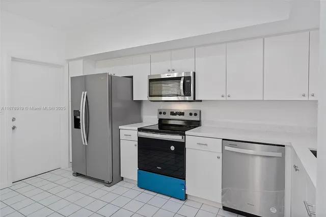 a kitchen with stainless steel appliances granite countertop a refrigerator and a stove top oven