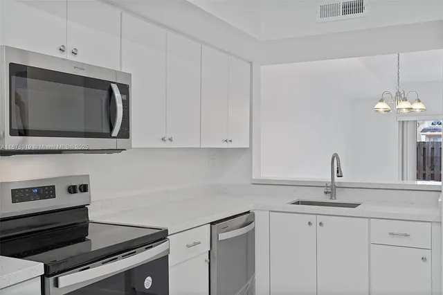 a kitchen with stainless steel appliances granite countertop a sink stove and microwave