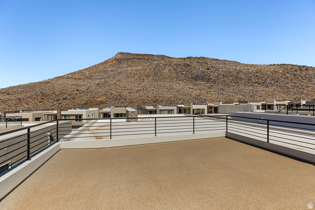 839 Walker Way St. George, UT 84770 - Photo 27 of 32 Expansive rooftop deck featuring a textured tan surface, black metal railings, and concrete privacy walls