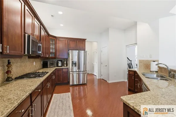 a kitchen with stainless steel appliances granite countertop a refrigerator and a stove top oven