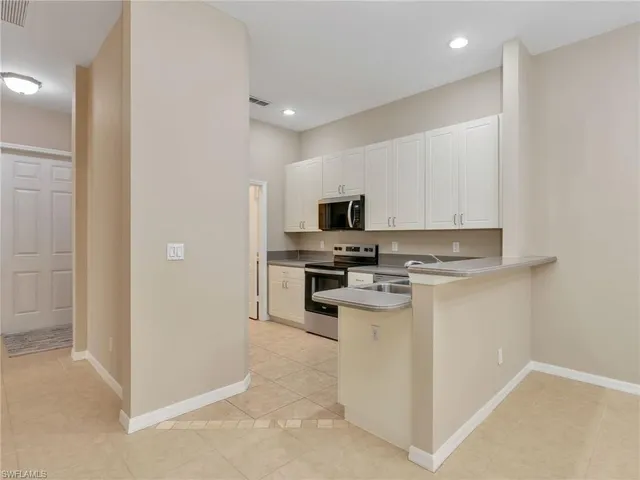 a kitchen with stainless steel appliances white cabinets and a refrigerator