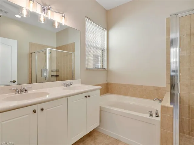 a bathroom with a tub a sink and mirror