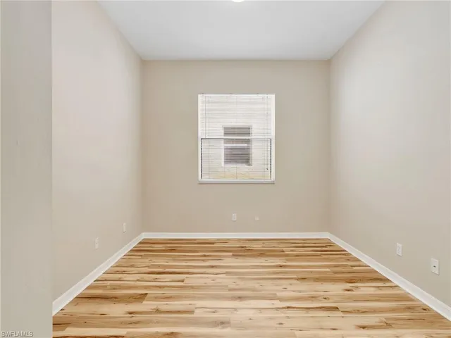 a view of a room with wooden floor and a window