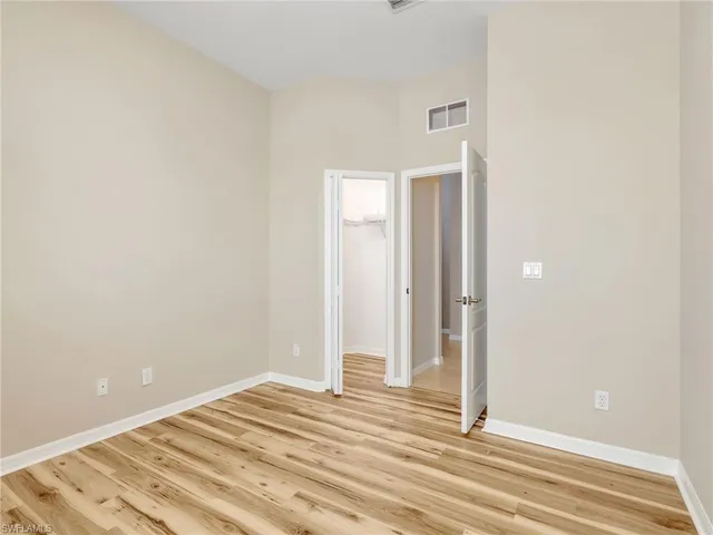 a view of a bedroom with wooden floor and bathroom