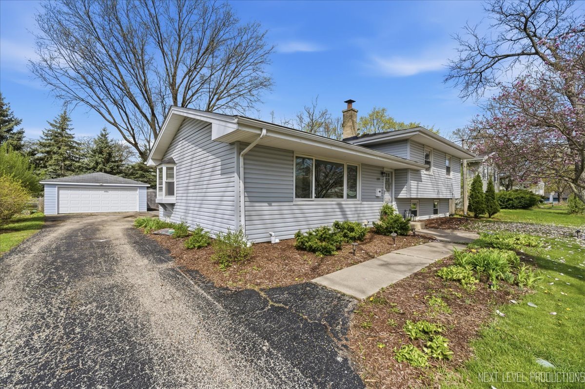 1209 Laurel Lane Naperville, IL 60540 - Photo 26 of 28 a front view of a house with a yard and potted plants