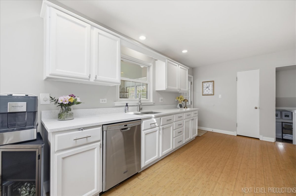 1209 Laurel Lane Naperville, IL 60540 - Photo 6 of 28 a kitchen with white cabinets and white appliances