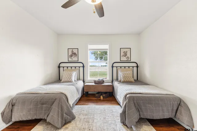 a bedroom with two beds and painting on the wall
