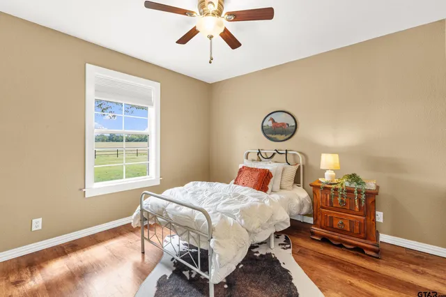 a bedroom with a bed a dresser and next to a window