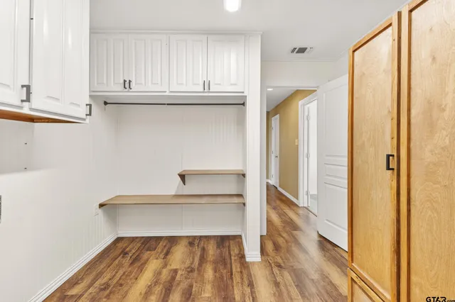 a view of a closet with wooden floor