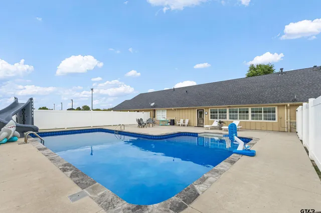 a view of a house with swimming pool and sitting area