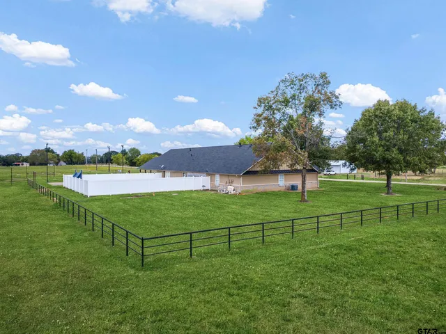 a view of a green field with wooden fence