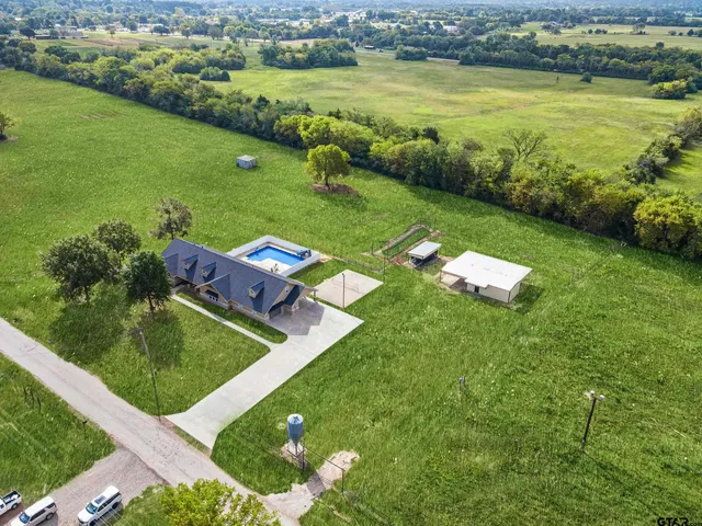 an aerial view of a house with a garden and lake view