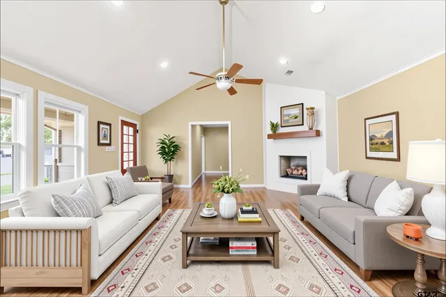 a living room with furniture a fireplace and a chandelier
