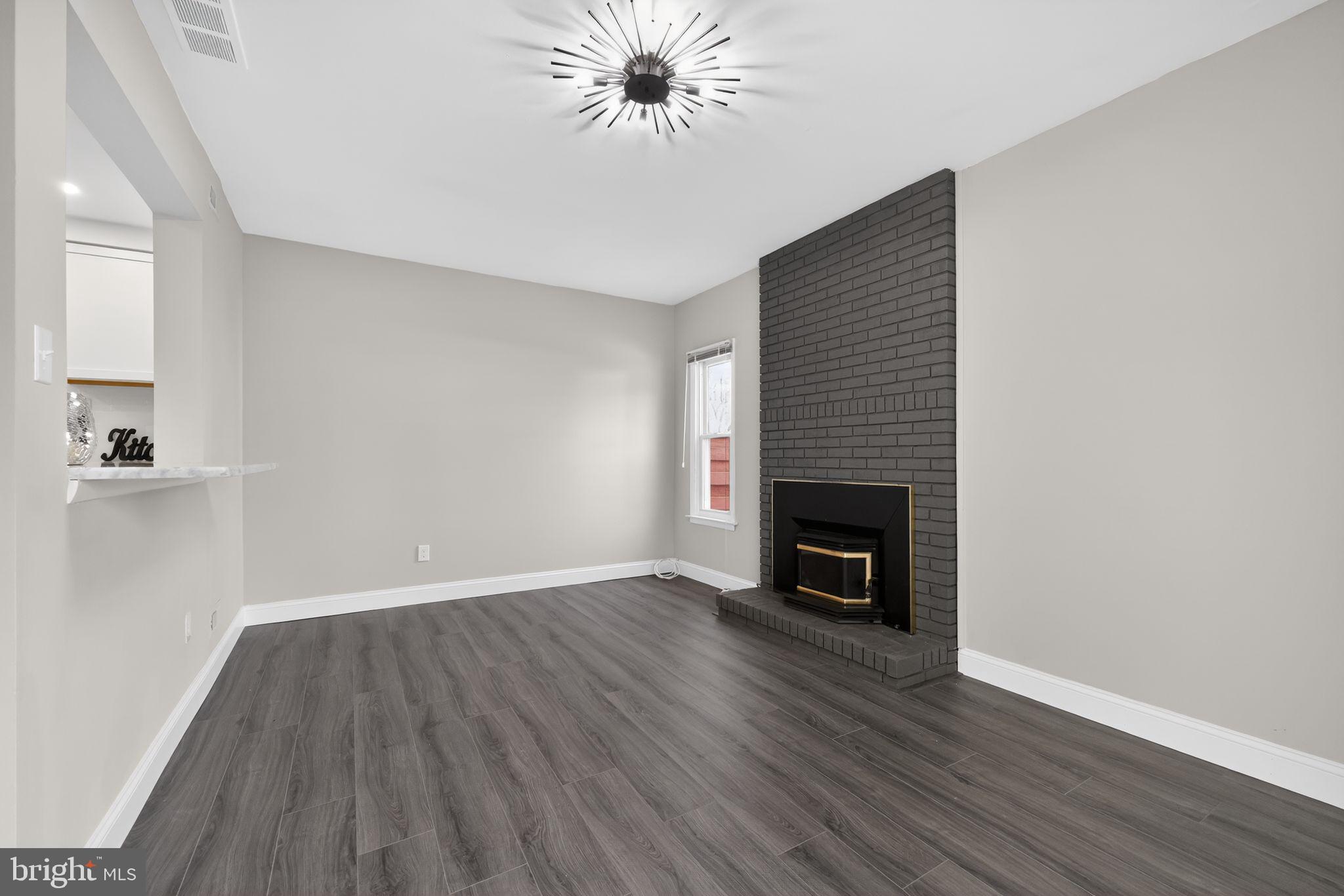 55 Adams Street Swedesboro, NJ 08085 - Photo 11 of 30 a view of an empty room with wooden floor fireplace and a window
